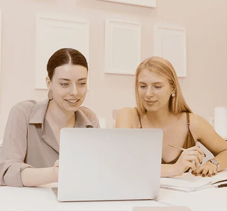 women-smiling-and-looking-at-the-laptop